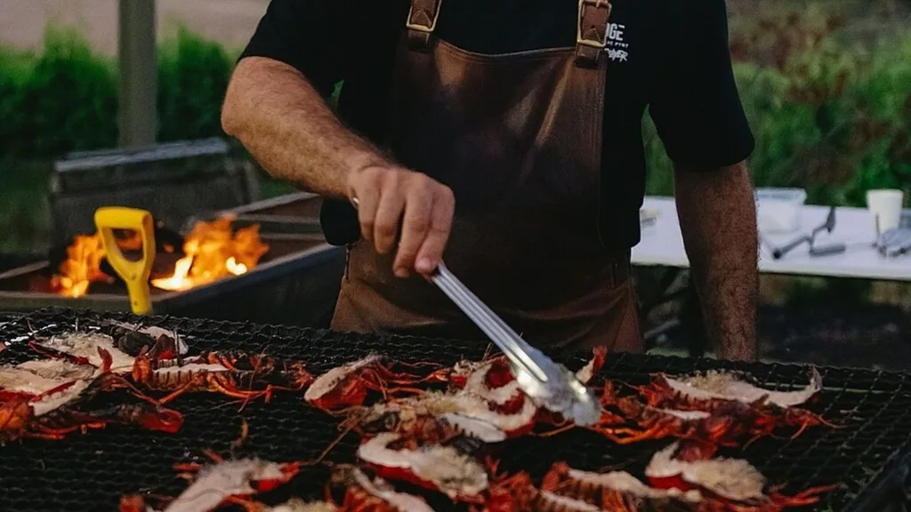 Male cooking on an outdoor barbeque at the Pair'd Burnt Ends & Friends event