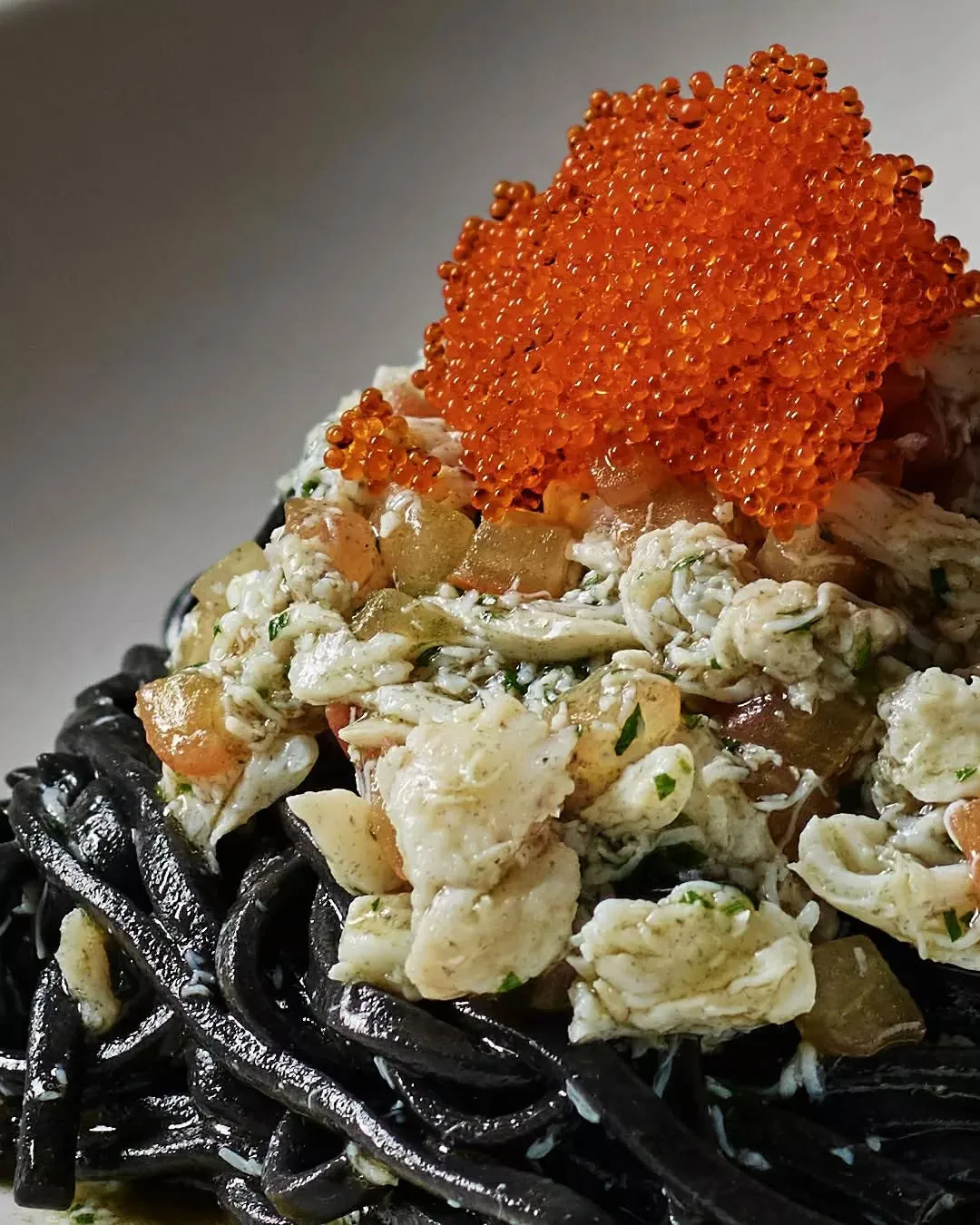 Squid ink linguine with blue swimmer crab topped with roe