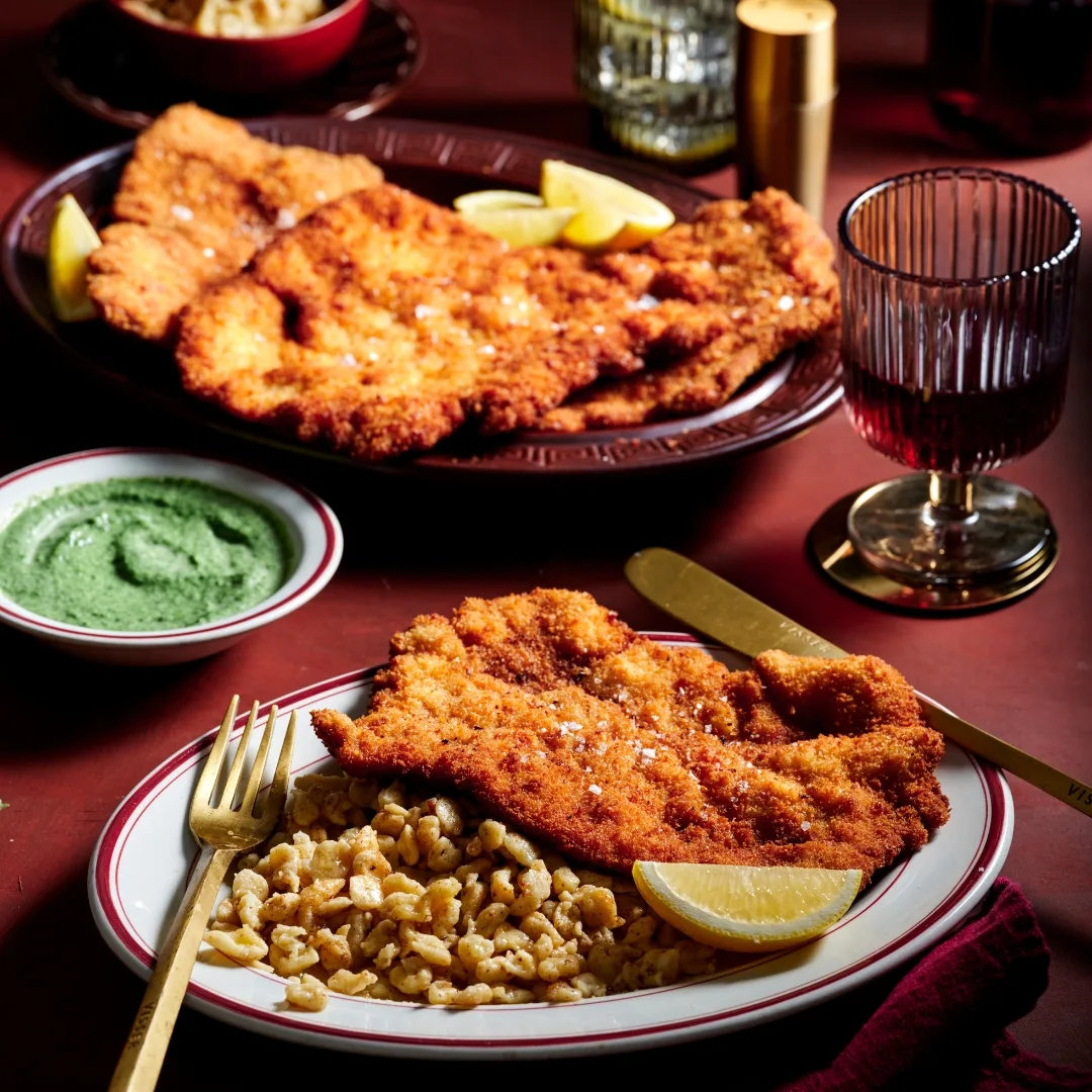 Corner 75's golden, crisp pork schnitzel with a side of norkedli, seasoned dough and creamed spinach