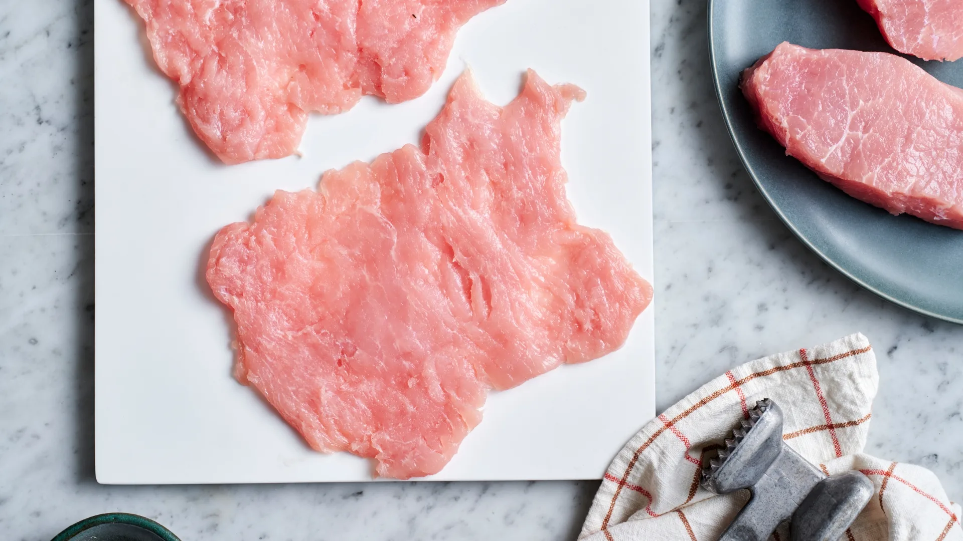 Butterflied pork laid flat after being pounded with a meat mallet 
