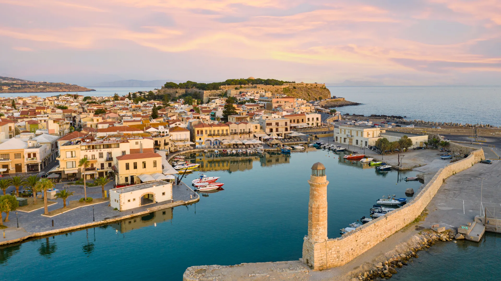Aerial view of the old Venetian harbour and lighthouse at dawn, Rethymno, Crete island, Greece