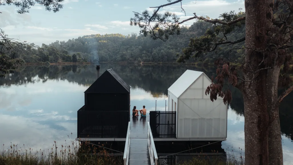 Two people sitting at Floating Sauna on the edge of Lake Derby in Tasmania
