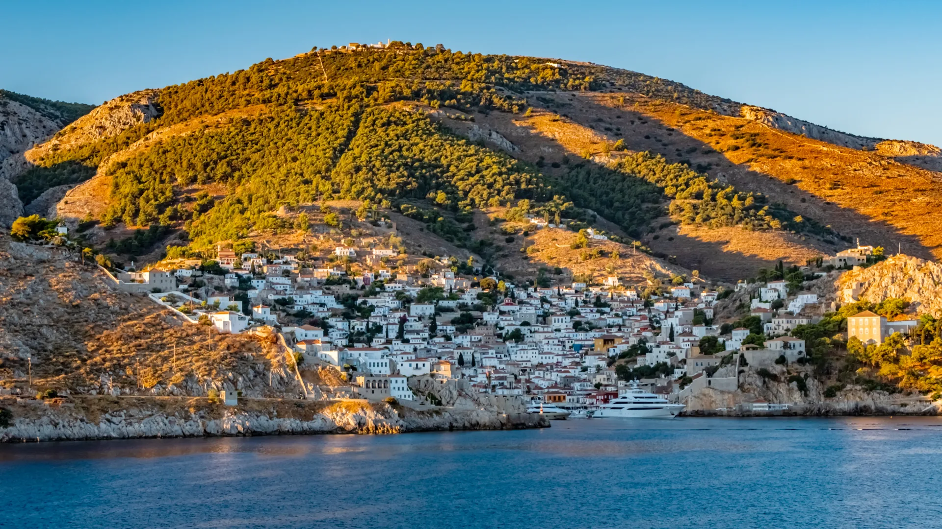 A view of the Greek island, Hydra. The view is from the sea as a cruise ship approaches the bay of Hydra in beautiful early morning light.