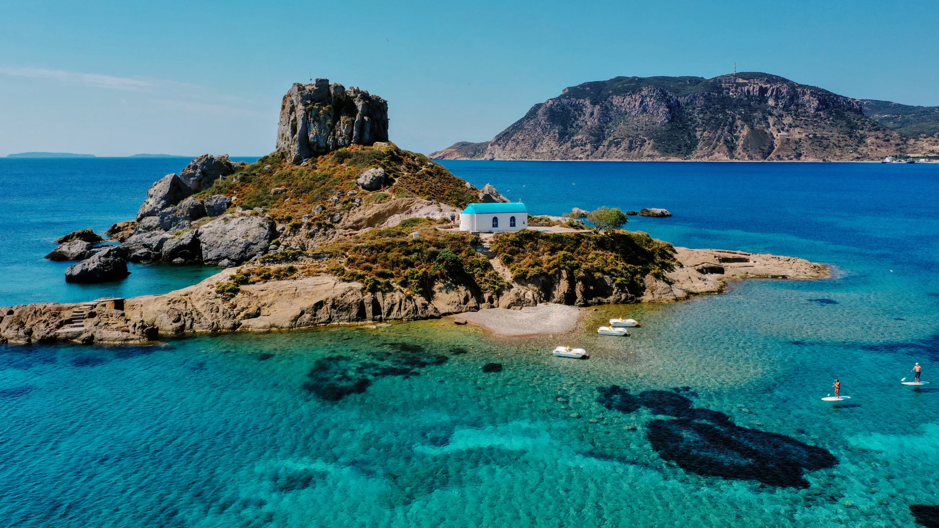 A natural view of the Kos Island and Kefalos Beach in Greece under a clear sunny sky.
