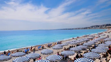 Blue and-white umbrellas on the beach at the Côte d’Azur.