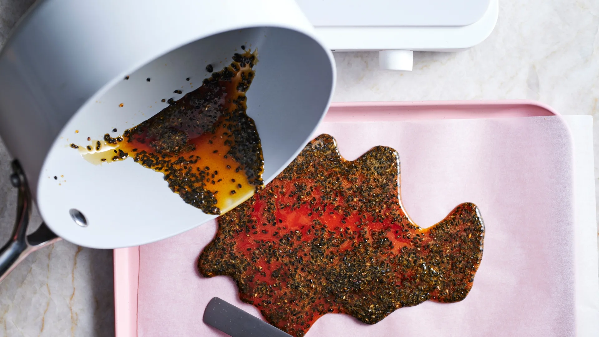 Black sesame praline on a small tray lined with baking paper for mochi filling