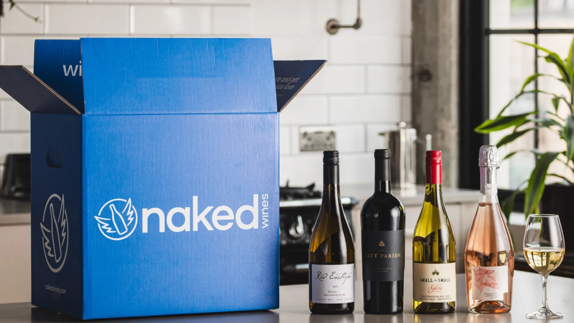 Wine bottles next to the Naked Wines delivery box 