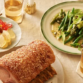A picture of crackling pork and a side salad of asparagus, green beans and pistachio.