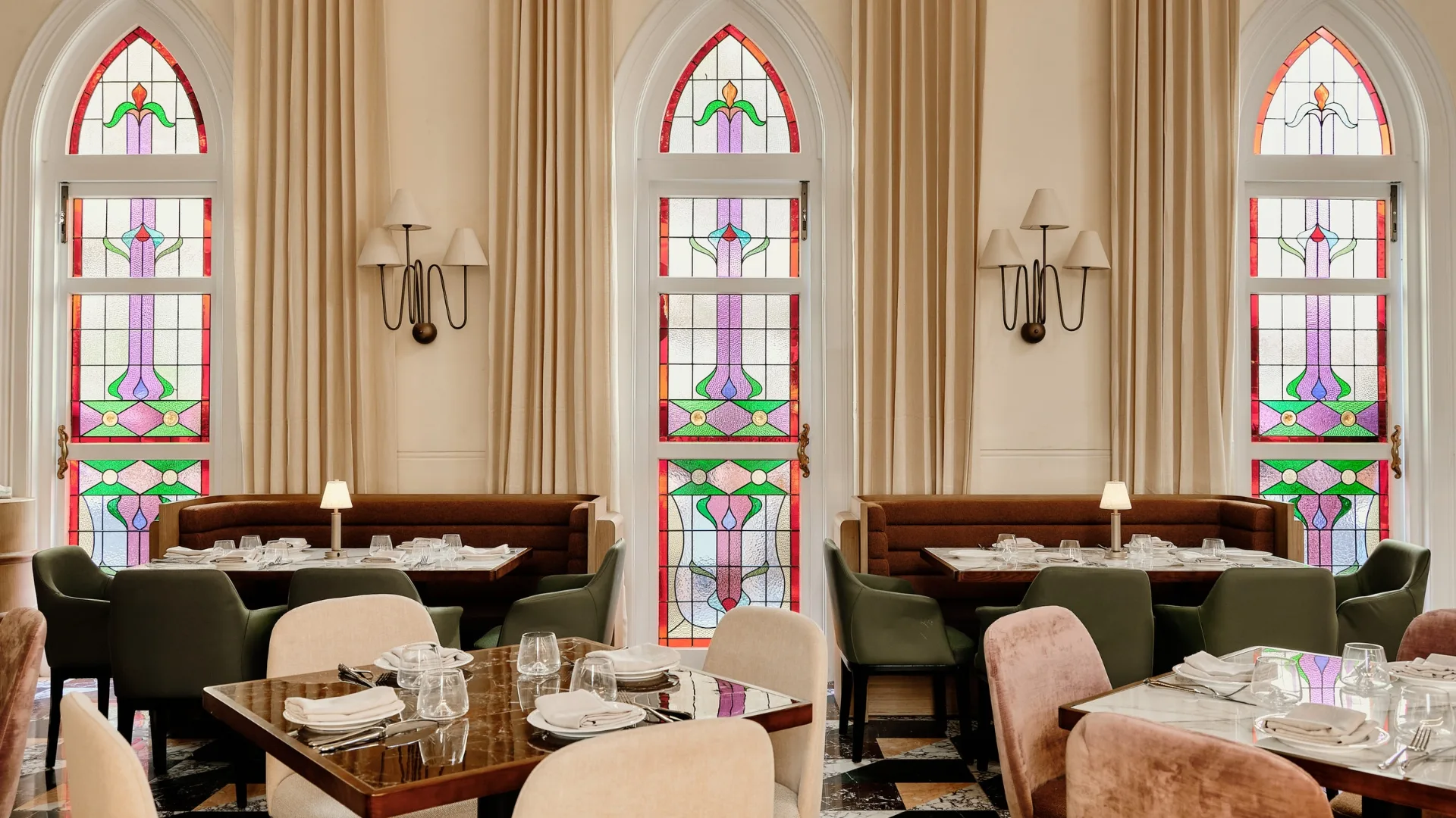 The light-filled interiors of the dining room at Aambra, Rose Bay, located within a former church. Stained-glass windows and custom pendant lights feature