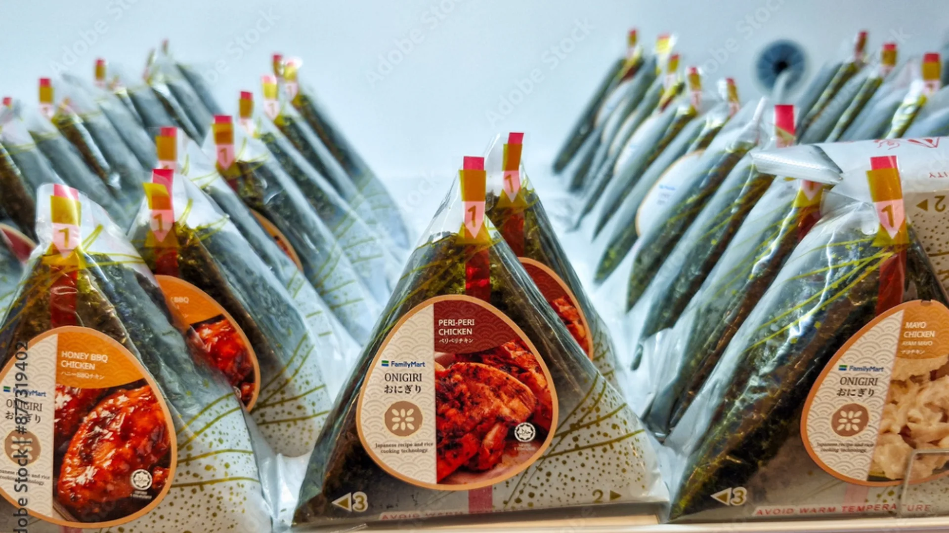 A few consecutive rows of wrapped onigiri on a shelf  