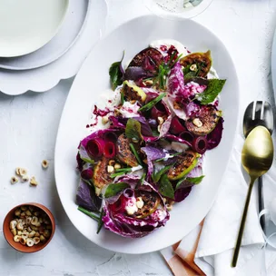 purple radicchio salad with figs and pickled beetroot on white serving bowl on white tablecloth