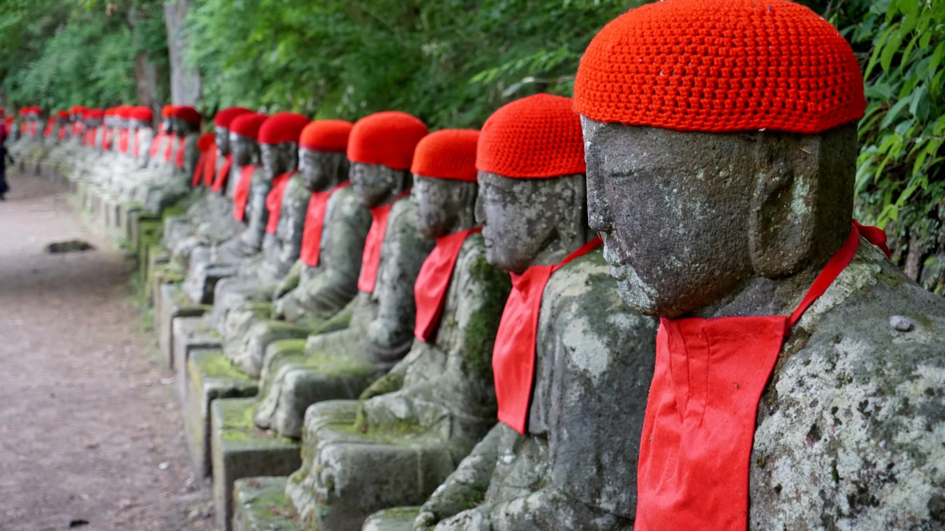 Stone Jizo statues with red caps.