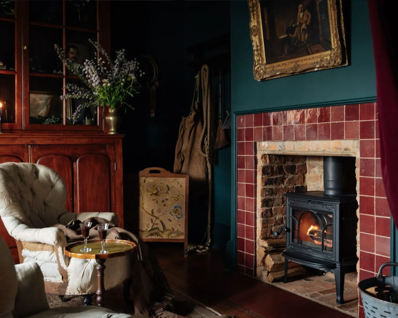 A cosy wine cellar space with a fireplace and moody palette.