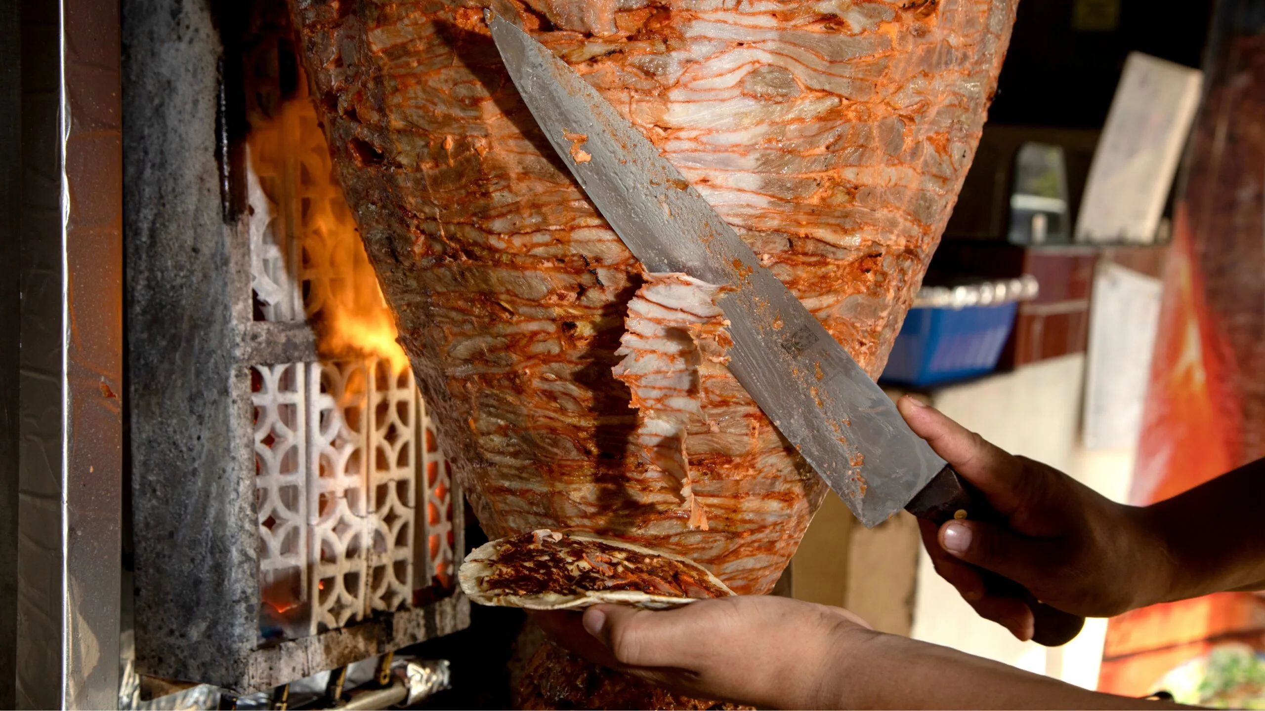 Pork being thinly shaved over a spit at El Vilsito