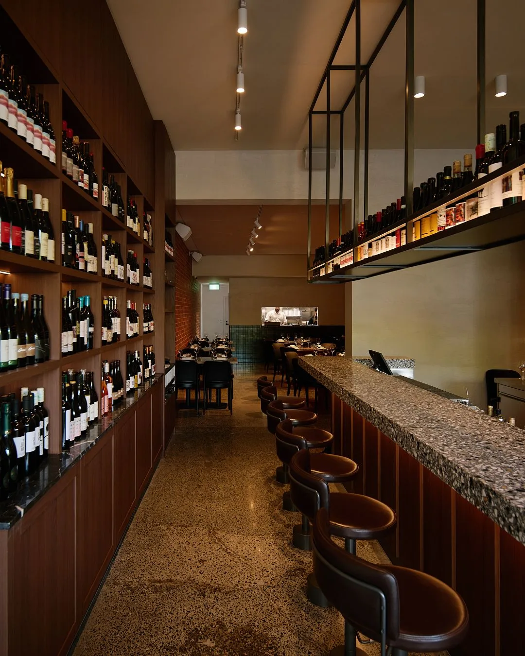 A long corridor flanked with wine shelves on one side and a long marble bar on the other at the new Bar Sophia in Melbourne