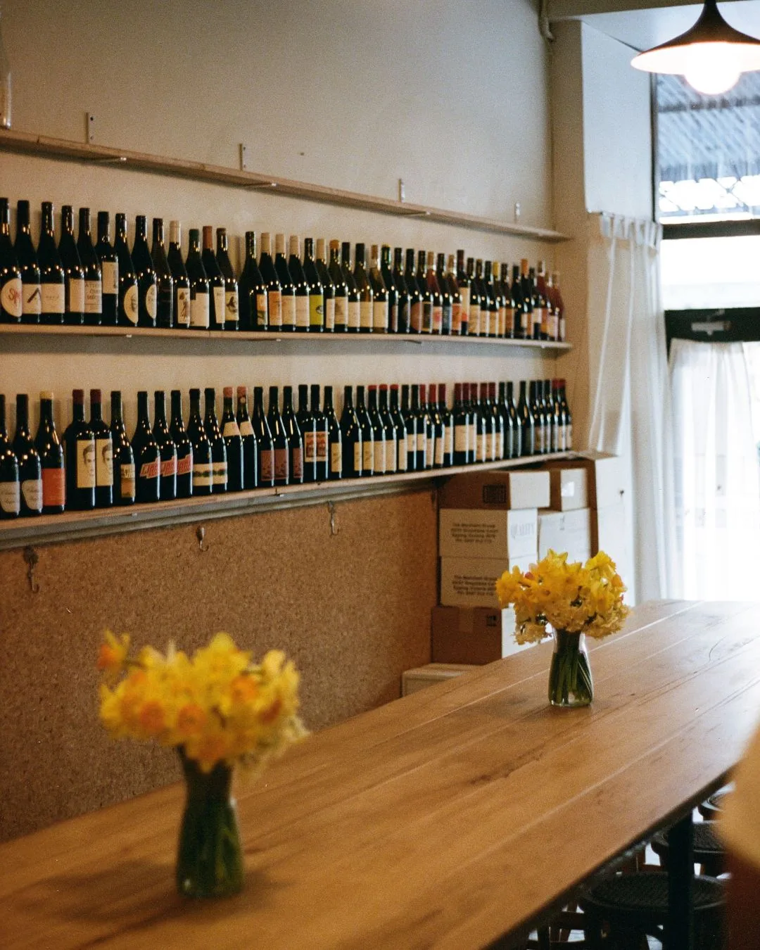 Shelves of wine and a long timber table at Boire wine bar in Melbourne