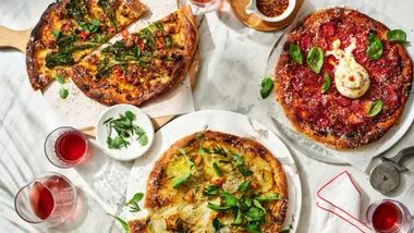 Three different pizzas on a table to represent different Italian recipes