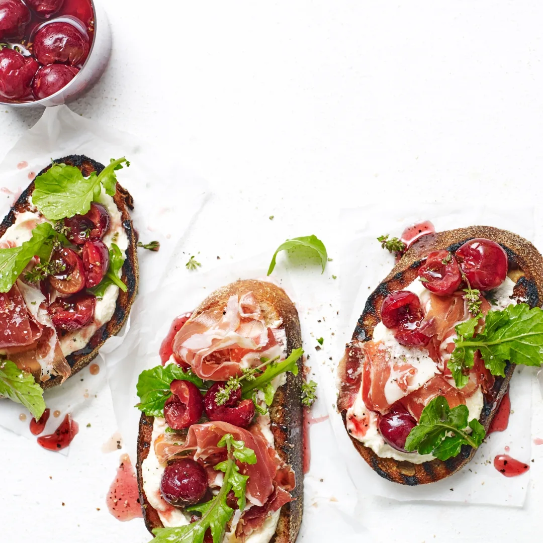 Easy, pickled cherry bruschetta with whipped feta and jamon