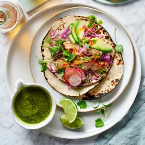 Smoky pork loin tacos with a bright salsa erde, pikcled onions and shaved cabbage salad
