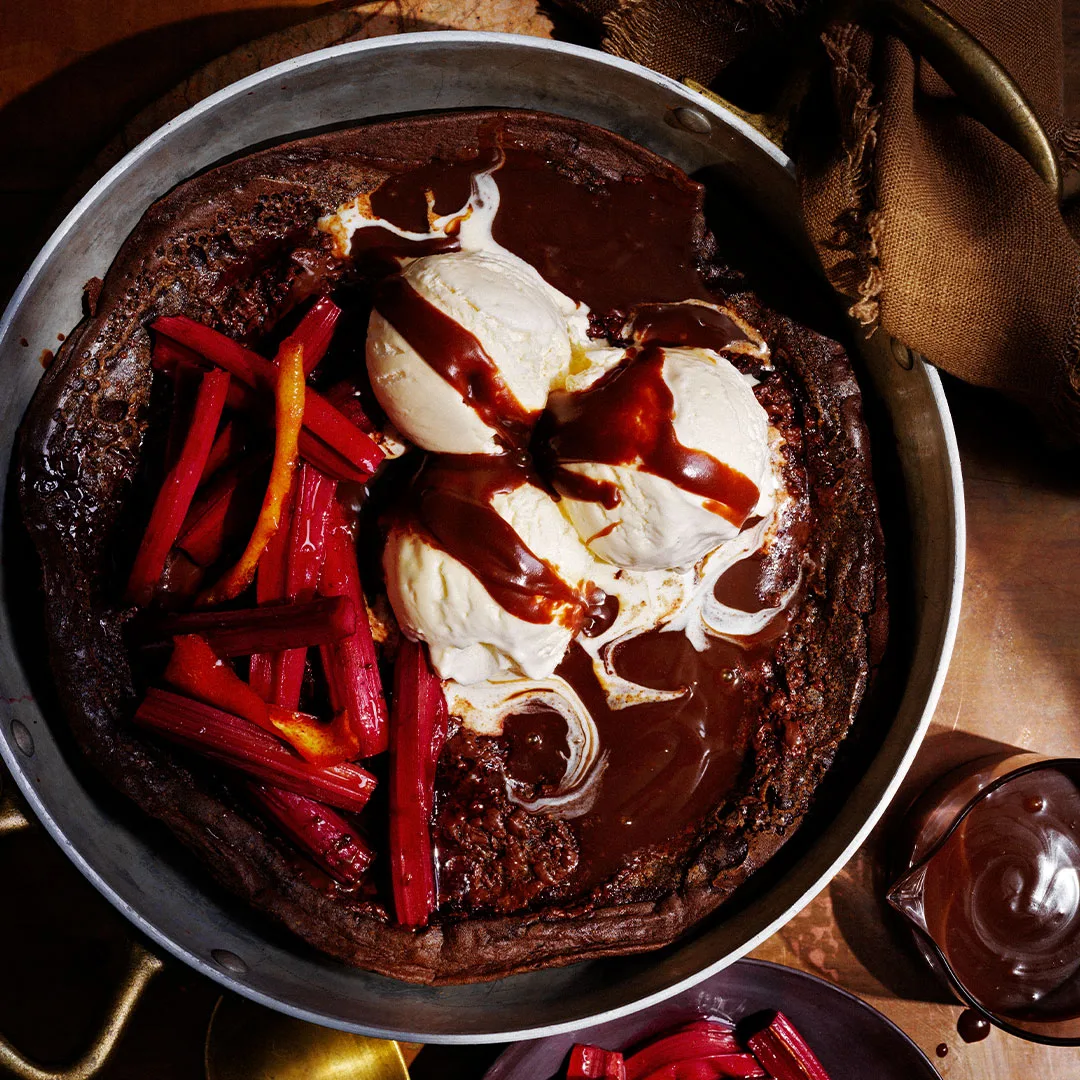 Chocolate Dutch baby topped with roasted rhubarb and ice-cream
