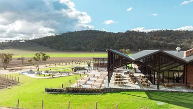 A large winery development overlooking grape vines and a rolling hill