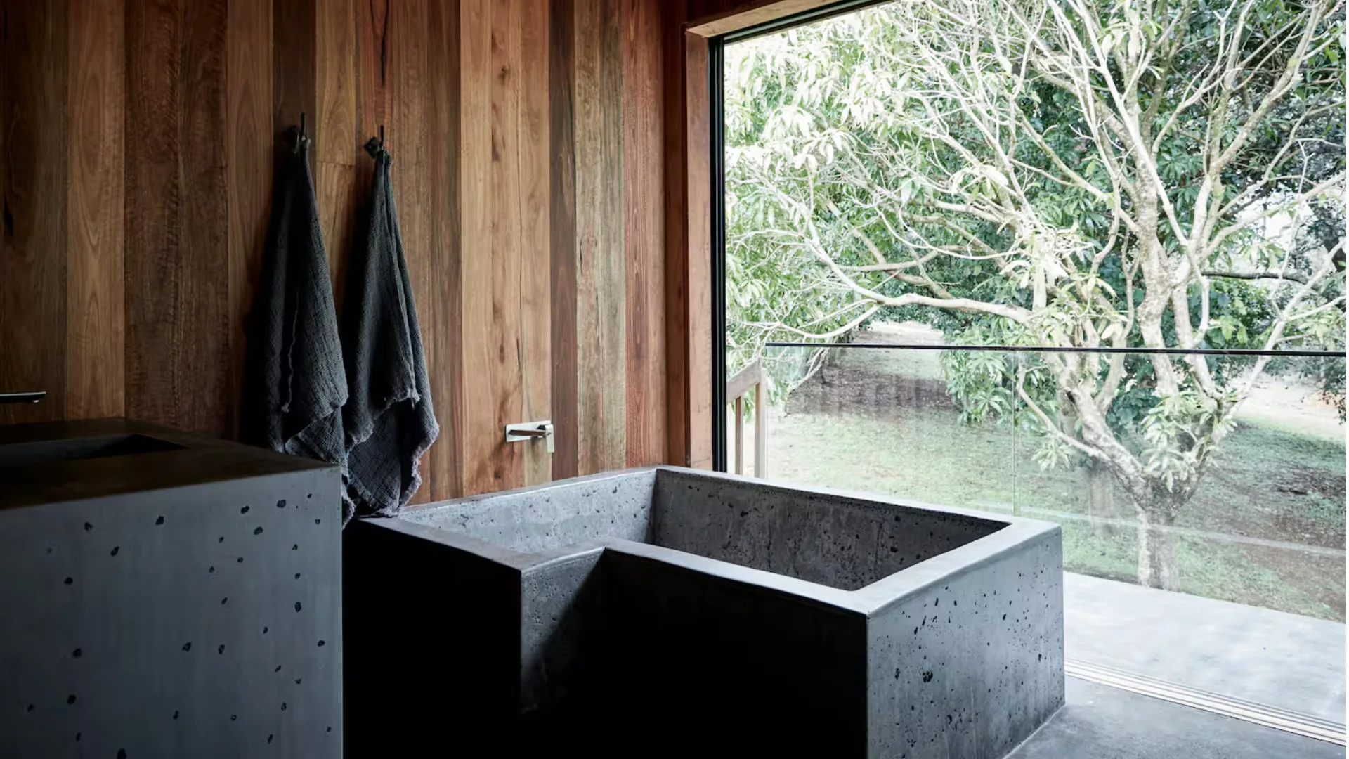 Bathtub with room for two and a view out to the orchard at Casas Secretas, an Airbnb in Byron Bay