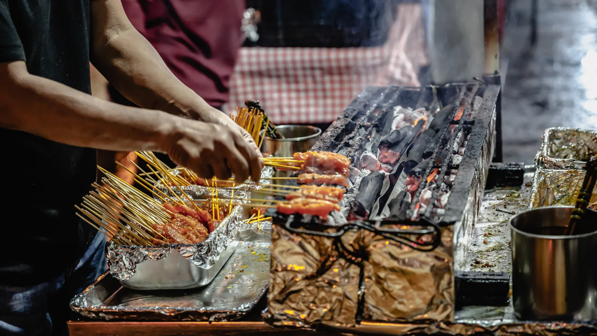 A grill and skewer expert at work on Lau Pa Sat hawker center's famous Satay Street. Singapore.