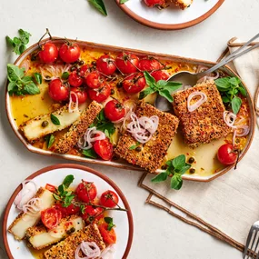 Sesame and nigella seed crusted haloumi with roast tomatoes
