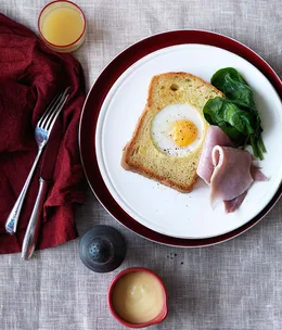 Eggs baked in brioche with ham, wilted spinach and hollandaise