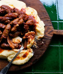 Tomato-braised sausages on parmesan polenta