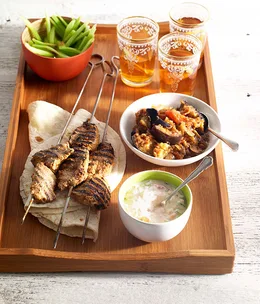 Lamb tikka kebabs with spiced eggplant, tomato raita and cucumber salad