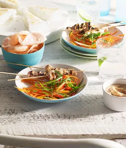 Chicken satay with pressed rice, peanut sauce and carrot salad
