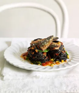 Squid ink tagliarini with pan fried sardines and tomato, chilli and basil sauce