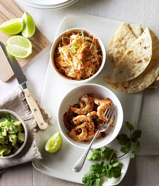 Soft prawn tacos with coleslaw, avocado and coriander