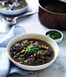 Duck, lentil and snail soup with garlic and parsley oil