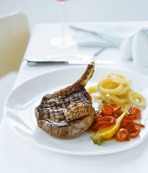 Rib-eye steak with cornmeal onion rings and charred tomato salad