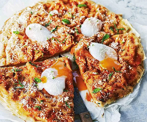 Flatbread stack with tomato sauce and poached eggs (pane frattau)