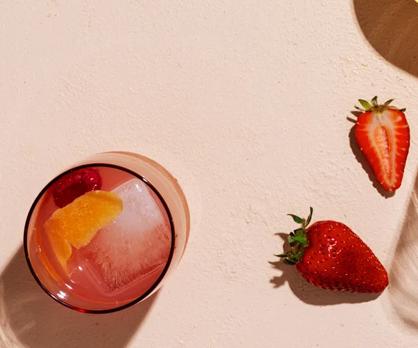 Glass of Rosé Spritz with strawberries on the side.