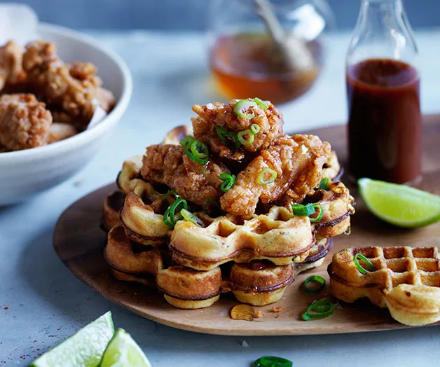 Spicy cornmeal waffles with popcorn chicken, honey and hot sauce