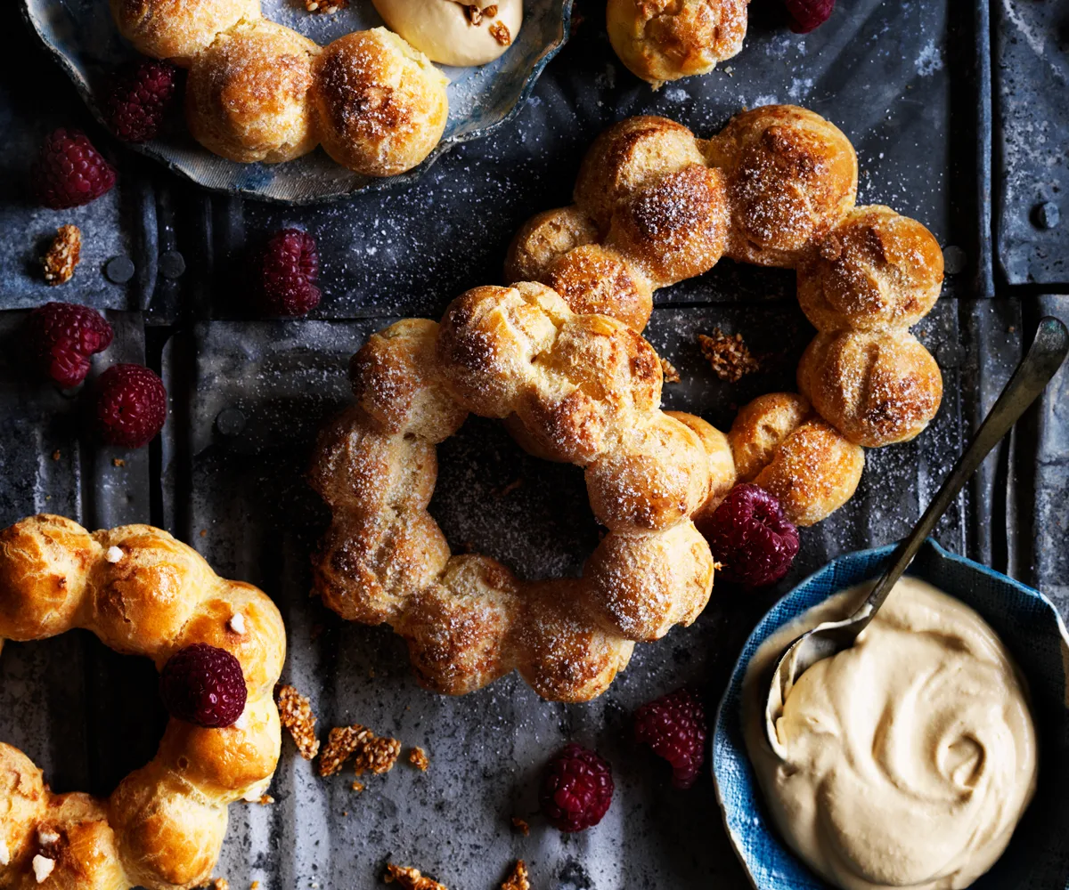 Choux wreaths with burnt-honey cream, raspberries and sesame praline