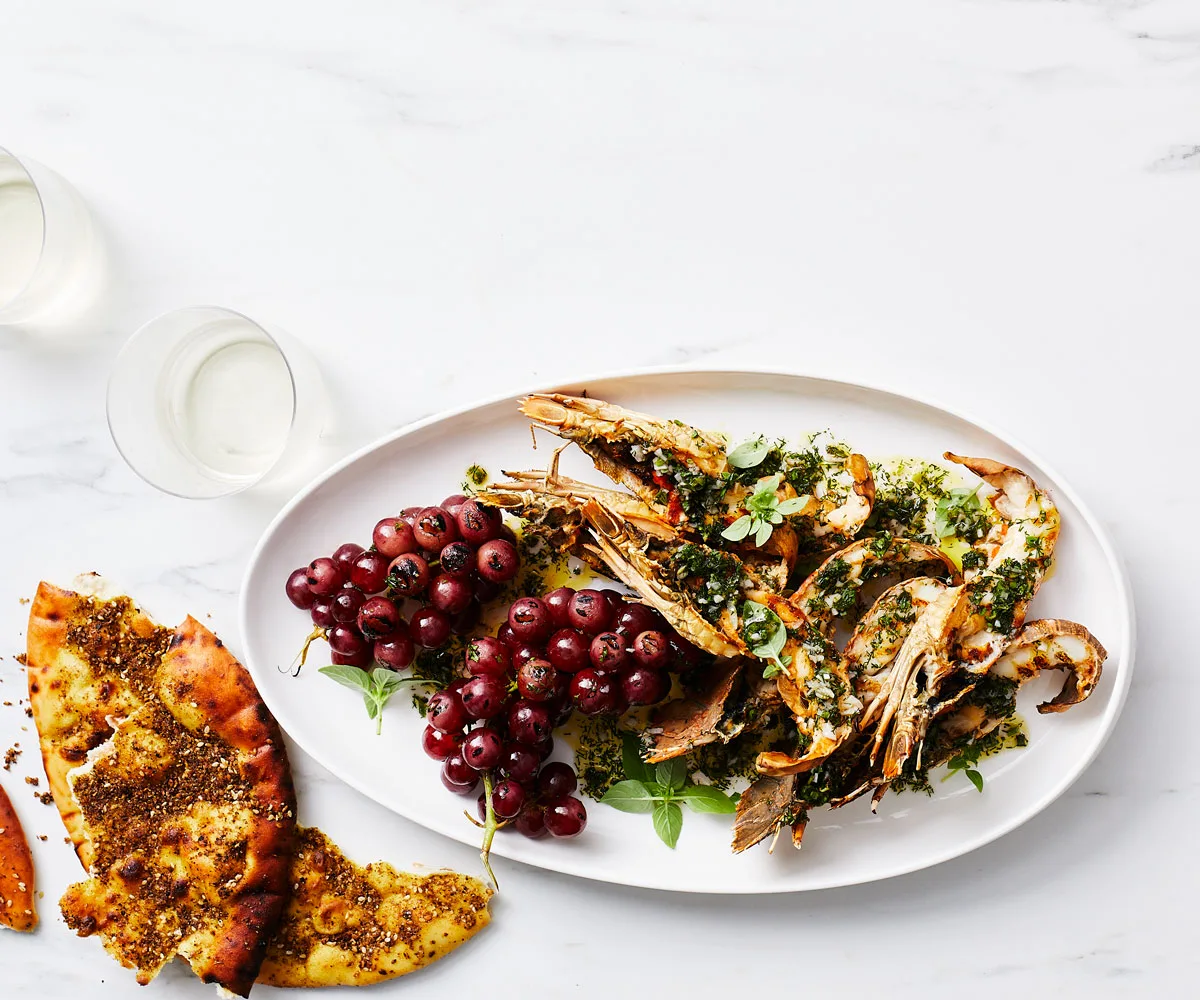 Image of halved Balmain bugs and a bunch of red grapes on a white platter