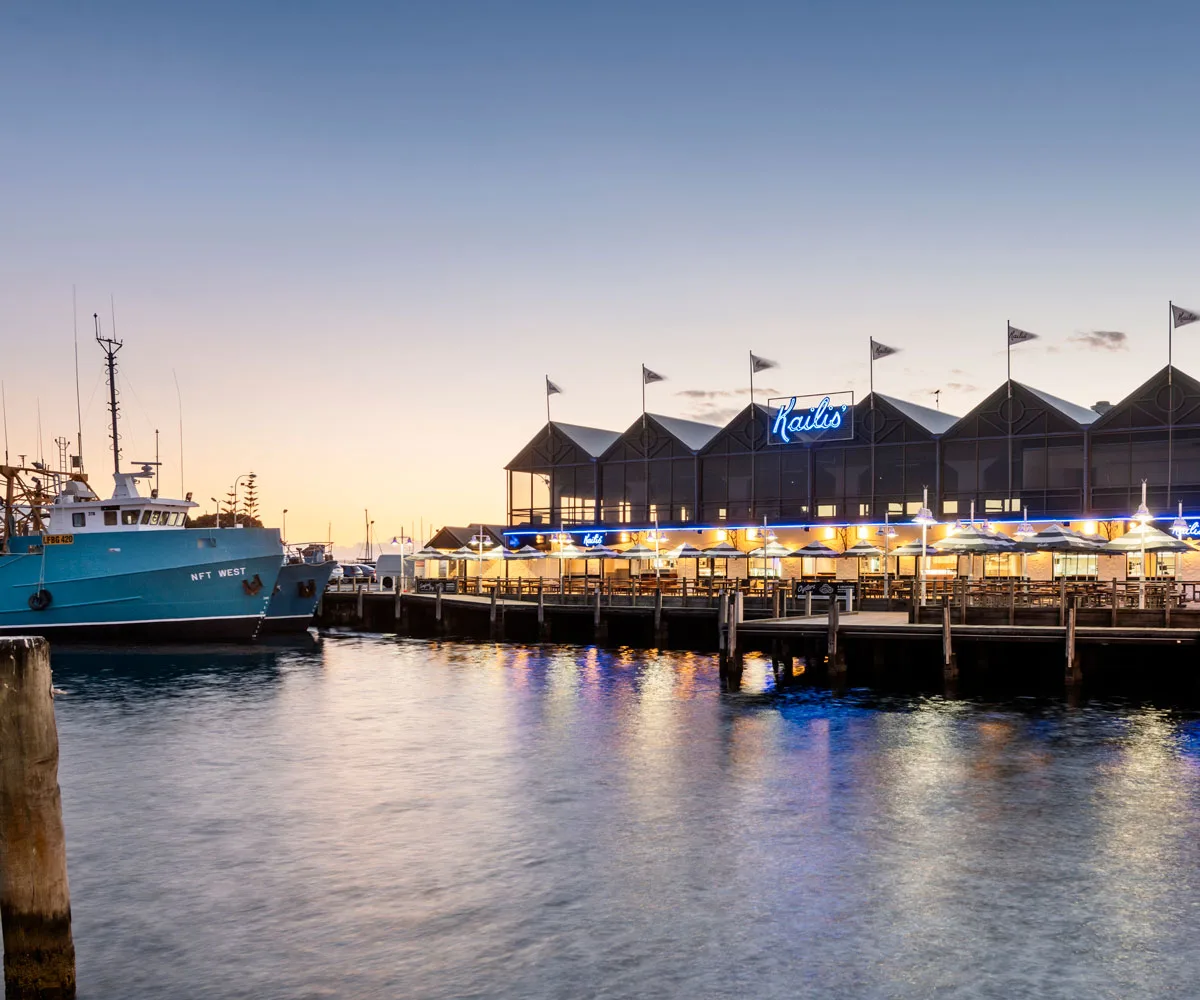 image of water with a blue boat and waterfront restaurant