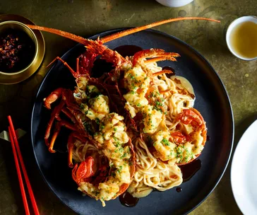 Bird's eye view of longevity noodles toped with two lobster halves