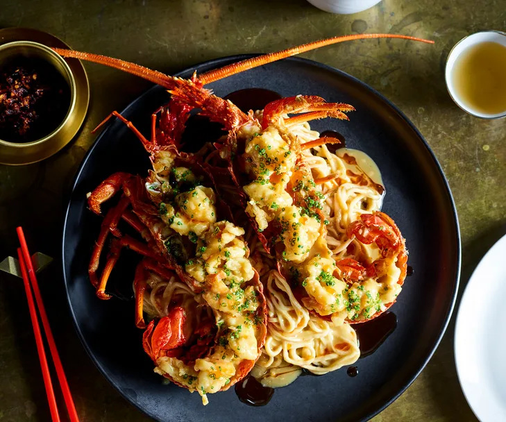 Bird's eye view of longevity noodles toped with two lobster halves