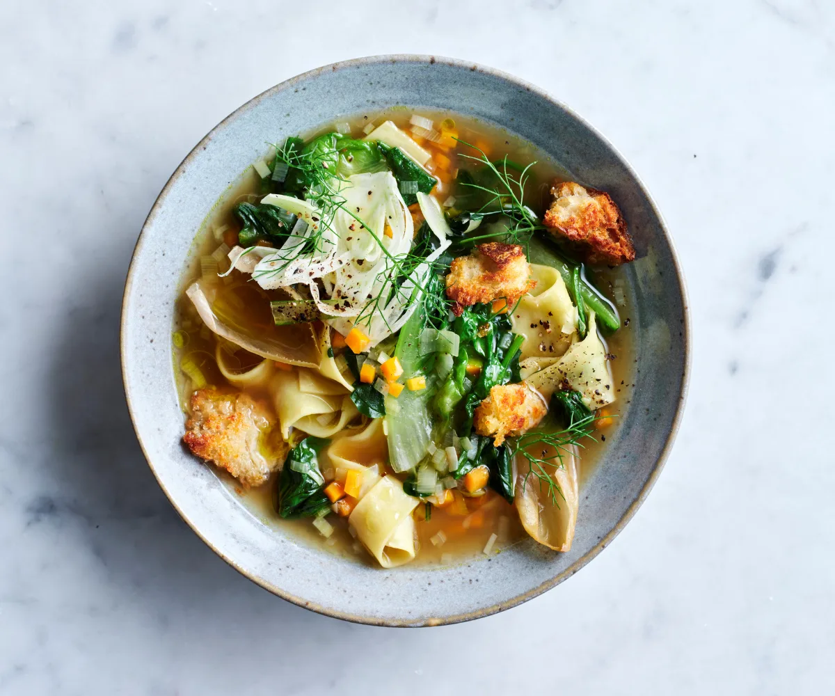 Bowl of soup with torn pasta noodles, fennel and croutons