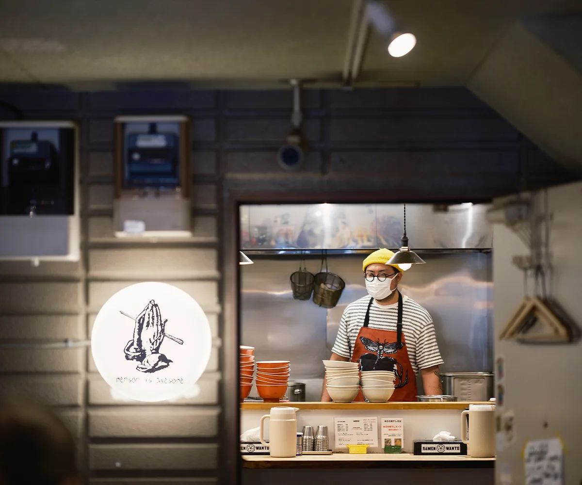Tokyo ramen shop interior with ramen chef in the kitchen and restaurant sign