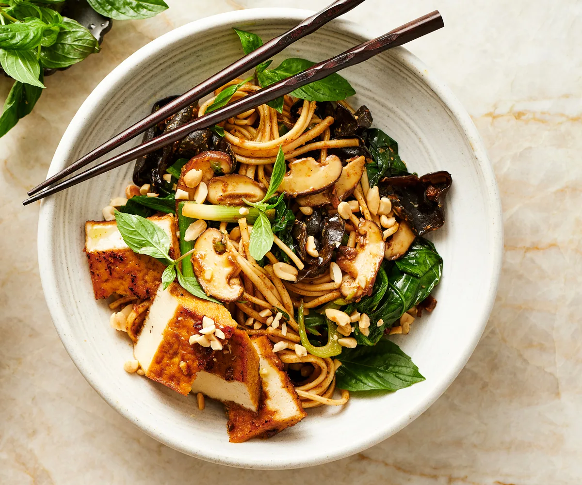 Udon noodles recipe stir fried with mustard greens, mushroom, tofu and peanut sauce