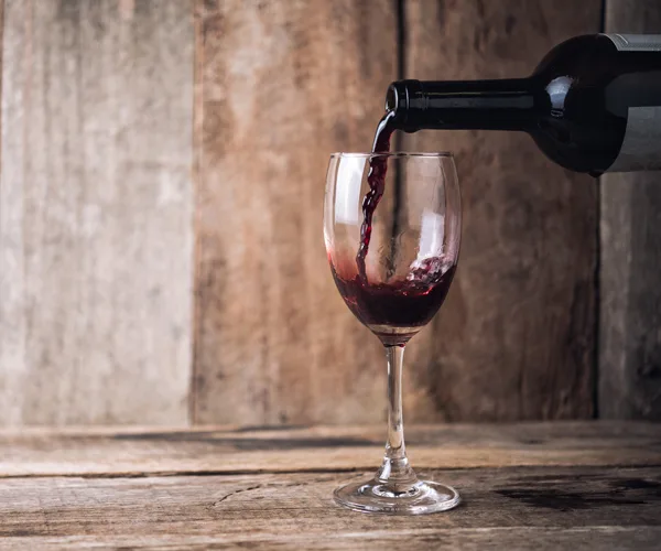 Red wine being poured into a wine glass.