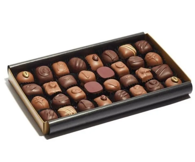 A variety of chocolates arranged neatly in a black and gold box.