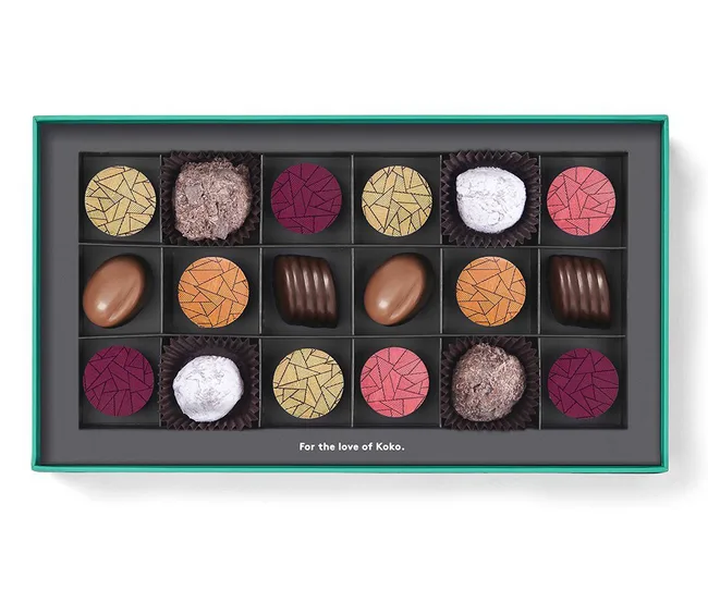 Box of assorted chocolates with colorful patterned tops inside a teal-edged box, labeled "For the love of Koko."